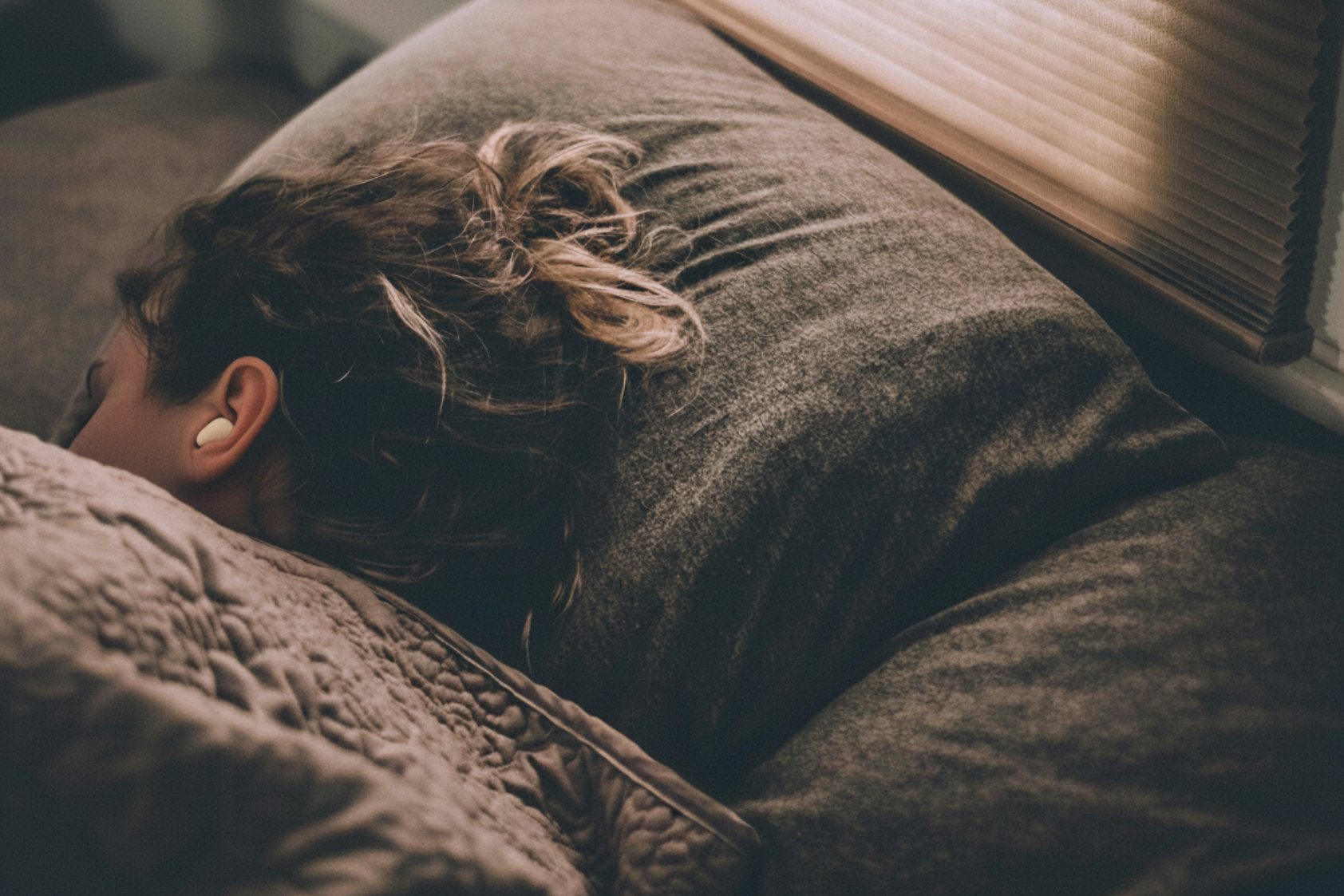 Personne dormant sur le côté, illustrant le confort et la réduction du bruit la nuit avec Dravem SleepQuiet.